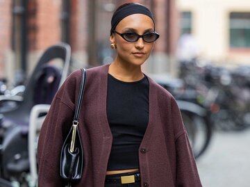 Frau trägt schwarzes Top, schwarze Shorts und einen braunen Cardigan | © Getty Images/Christian Vierig