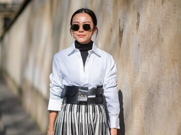 Streetstyle von Frau, die weiße Bluse über schwarzem Rollkragenpullover trägt | © Getty Images/Christian Vierig