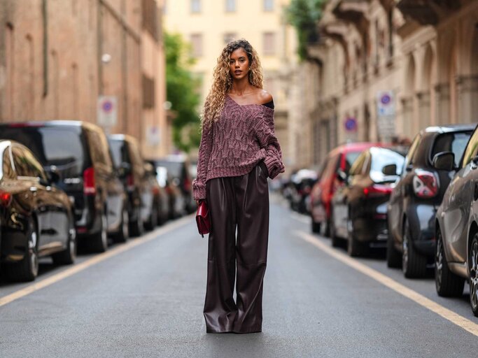 Frau trägt bordeaux Lederhose und bordeaux Pullover | © Getty Images/Edward Berthelot 