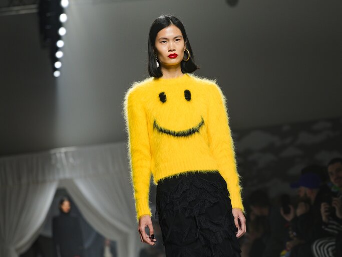 Model mit gelbem Smiley-Pullover auf dem Laufsteg von Moschino | © Getty Images/Jacopo Raule