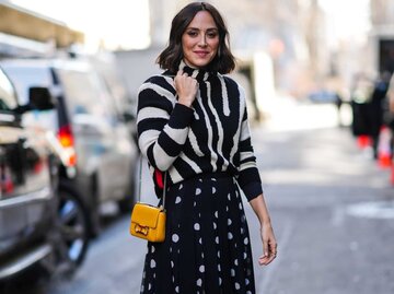 Frau trägt Rock mit Polka Dots und Pullover im Zebramuster | © Getty Images/Edward Berthelot