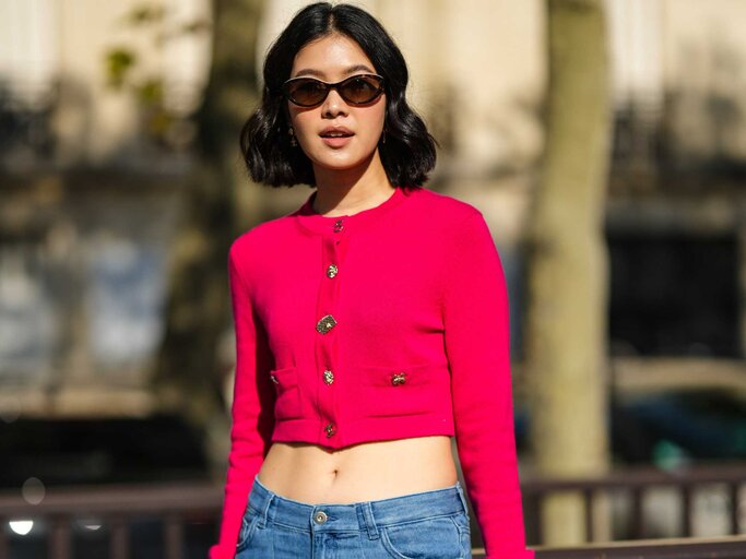 Frau trägt Jeans und Cropped Cardigan | © Getty Images/Edward Berthelot