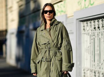 Frau im khaki-grünen Trenchcoat | © Getty Images/Edward Berthelot 