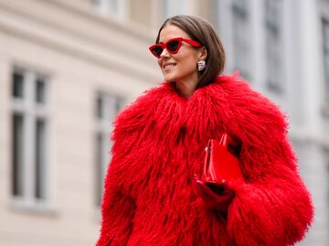 Streetstyle von Nina Sandbech in rotem Fake-Fur-Mantel und roter Sonnenbrille | © Getty Images/Edward Berthelot