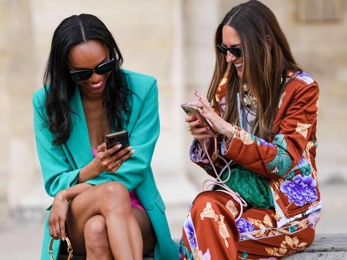 Alba Garavito Torre und Emilie Joseph mit Handy in der Hand | © Getty Images/Edward Berthelot/Kontributor