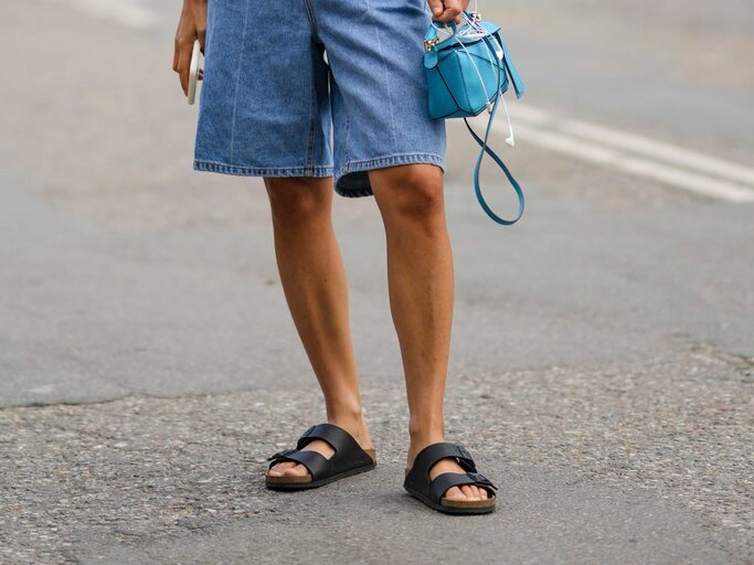 Frau in Jeans-Shorts trägt Birkenstock | © Getty Images/Edward Berthelot