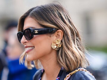 Frau trägt Sonnenbrille und goldenen Schmuck | © Getty Images/Edward Berthelot 