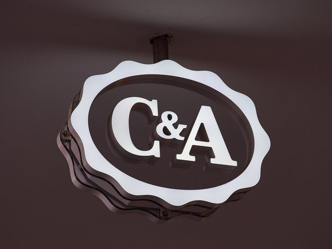 Weißes C&A-Logo auf schwarzem Hintergrund | © AdobeStock/Claudia Nass