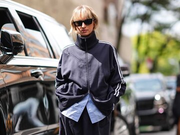 Frau mit Trainingsjacke und Sonnenbrille | © Getty Images/Edward Berthelot