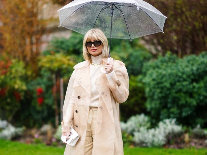 Xenia Adonts trägt einen Regenmantel und einen Regenschirm | © Getty Images/Edward Berthelot