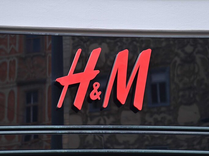 Rotes H&M Logo auf einer Glasfassade eines H&M-Shops. | © Adobe Stock/panithi33