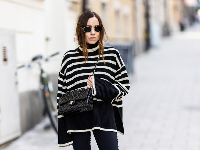 Streetstyle von Tina Lundin in schwarzem Pullover mit Streifen | © Getty Images/Michael Campanella