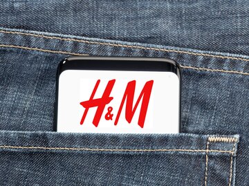 Handy mit H&M-Logo in der Hosentasche einer blauen Jeans | © AdobeStock/Formatoriginal