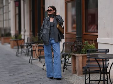 Streetstyle von Mary L. Jean in blauer Wide Leg Jeans und schwarzer Lederjacke | © Getty Images/Jeremy Moeller