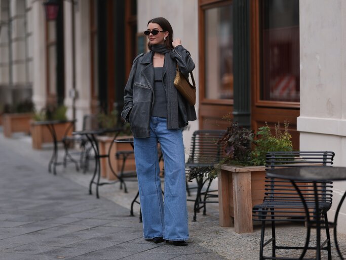 Streetstyle von Mary L. Jean in blauer Wide Leg Jeans und schwarzer Lederjacke | © Getty Images/Jeremy Moeller