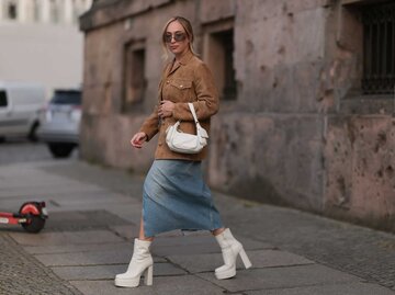 Frau trägt beige Plateau Stiefel zum langen Jeansrock. | © Getty Images/Jeremy Moeller