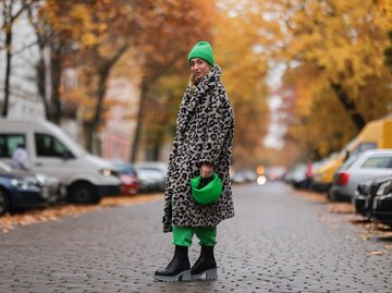 Streetstyle von Sonia Lyson in Mantel mit Leopardenmuster, grünen Jogginghosen und Accessoires  | © Getty Images/Jeremy Moeller