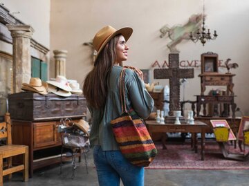 Frau mit Hut beim Vintage-Shopping. | © Getty Images/Tony Anderson