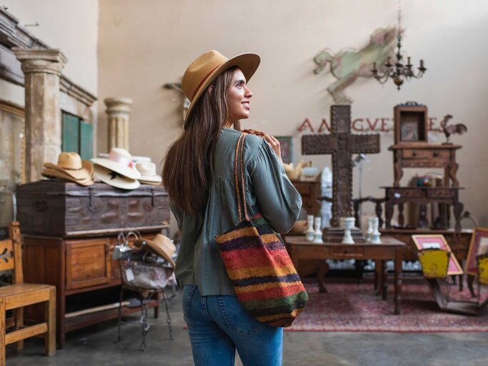 Frau mit Hut beim Vintage-Shopping. | © Getty Images/Tony Anderson