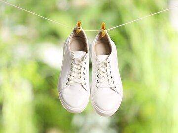 Weiße Sneaker hängen an Wäscheleine | © AdobeStock/New Africa