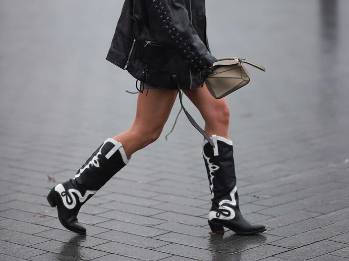 Frau trägt schwarze Cowboystiefel und einen Rock | © Getty Images/Jeremy Moeller