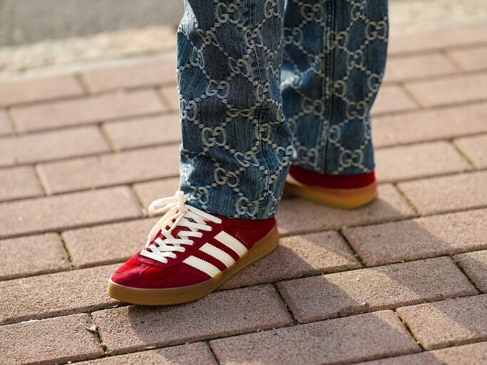 Streetstyle von rotem "Gazelle"-Sneaker von Adidas mit weißen Streifen | © Getty Images/Edward Berthelot