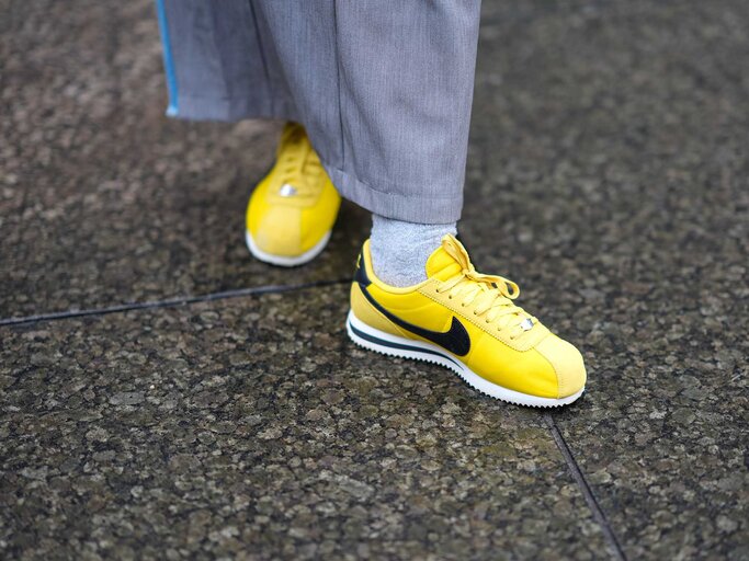 Frau trägt gelbe Sneaker von Nike. | © Getty Images/Edward Berthelot