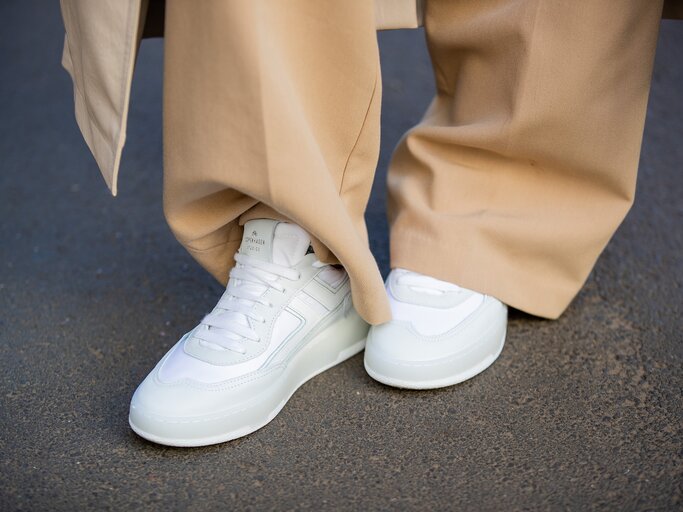 Streetstyle von weißen Sneakern und beigen, weiten Hosen | © Getty Images/Christian Vierig