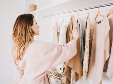 Frau steht im Bademantel vor ihrem Kleiderschrank | © shutterstock/Kokulina 