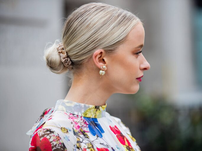 Frau mit strengem Dutt im Nacken und Scrunchie | © Getty Images | Christian Vierig