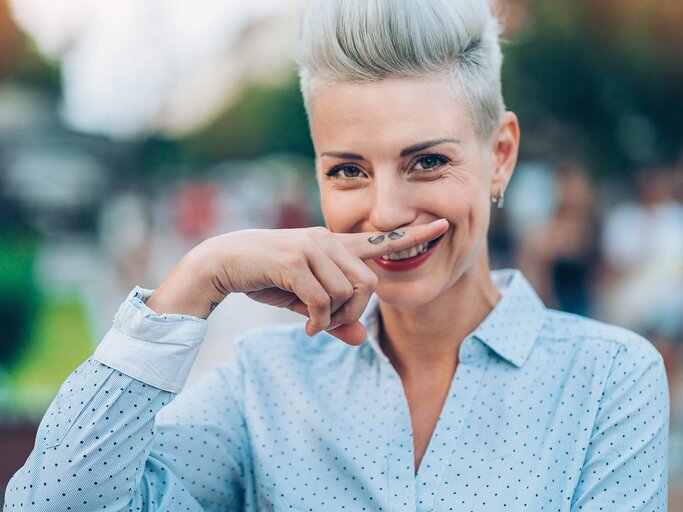 Frau deutet mit einem Finger einen Damenbart an. | © gettyimages.de | pixelfit