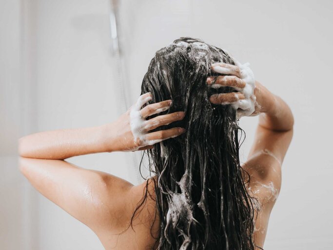 Frau wäscht sich unter der Dusche die Haare. | © Adobe Stock/sarayutsridee