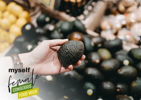 Hand hält Avocado im Supermarkt