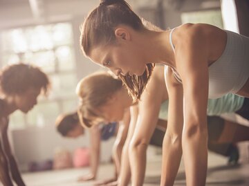  Junge Frauen in Stützposition bei Workout in einem Fitnesskurs | © Getty Images