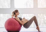 Schwangere Frau trainiert mit dem Schwebesitz auf einem Gymnastikball. | © Getty Images / Vasyl Dolmatov