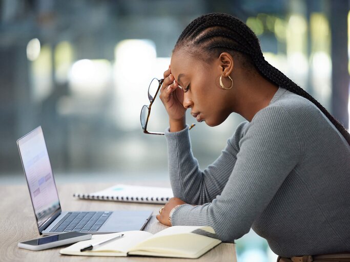 Gestresste Frau am Arbeitsplatz | © Getty Images/PeopleImages