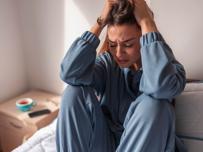 Ängstliche Frau verzweifelt auf dem Bett | © Getty Images/vladans