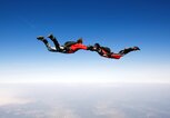 Paar im freien Fall beim Fallschirmsprung vor blauem Himmel | © gettyimages.de | vuk8691