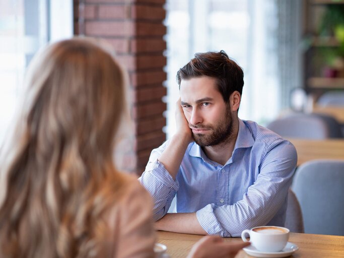 Mann stützt sein Gesicht beim Date auf die Hand und hat ein schlechtes Gefühl | © gettyimages.de | Prostock-Studio