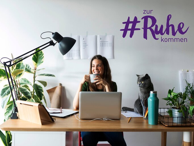 Junge Frau am Homeoffice Arbeitsplatz mit Tasse Kaffee und Katze auf dem Tisch | © gettyimages.de | Westend61