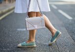 Streetstyle einer Besucherin in weißem Kleid, türkisfarbenen Chanel-Espadrilles und mit Dior Handtasche bei der Menswear Fashion Week in London | © Getty Images / Christian Vierig