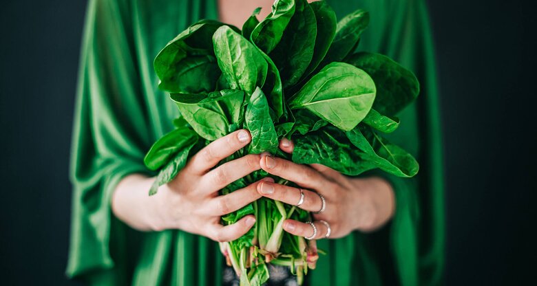 Frau hält frischen Spinat in den Händen, auch Baby Leaf genannt | © iStock | knape