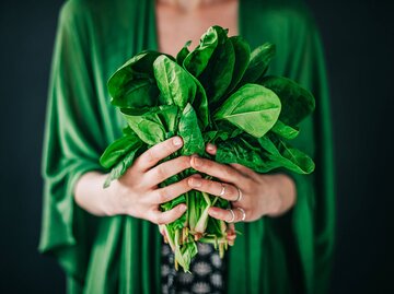 Frau hält frischen Spinat in den Händen, auch Baby Leaf genannt | © iStock | knape