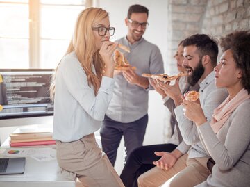 Geschäftsleute beim gemeinsamen Essen im Büro | © iStock | Ivanko_Brnjakovic