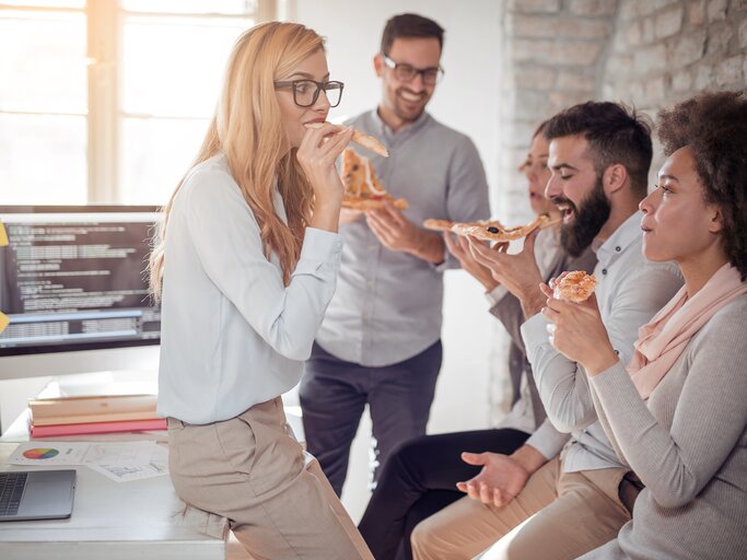 Geschäftsleute beim gemeinsamen Essen im Büro | © iStock | Ivanko_Brnjakovic