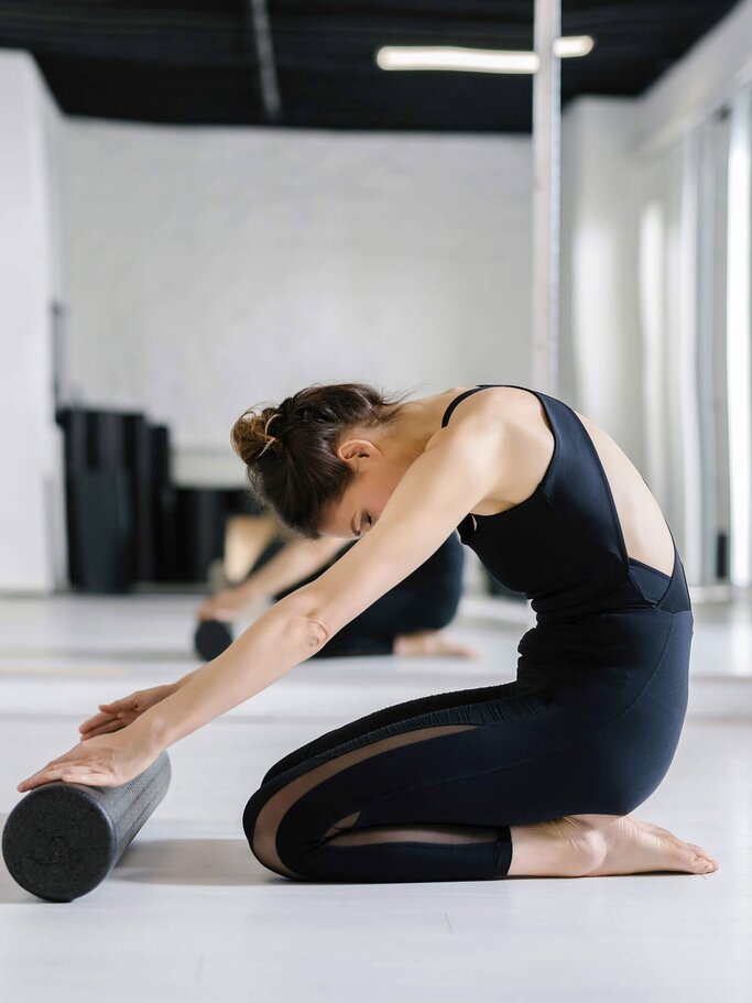 Junge Frau bei einer Pilates Übung  | © iStock | LuminaStock