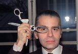 Karl Lagerfeld im Jahr 1987, wie er sich eine Schere vor die Augen hält | © Getty Images | PIERRE GUILLAUD 