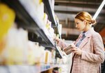 Frau schaut sich im Supermarkt glutenfreie Produkte an | © iStock | Aja Koska