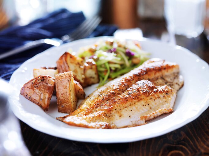 In der Pfanne gebratener tilapia mit asiatischem Kohl und Röstkartoffeln | © iStock | rez-art