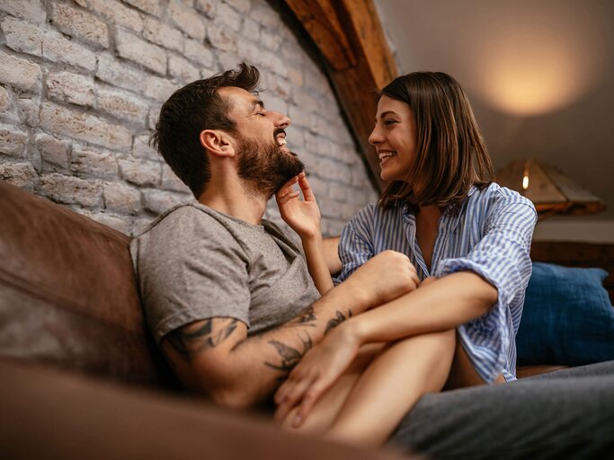 Junges Paar neckt sich auf dem Sofa | © iStock | bernardbodo